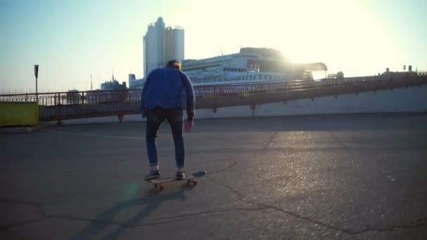 young man skateboarding in the sea port at dawn slow motion - Footage, Video