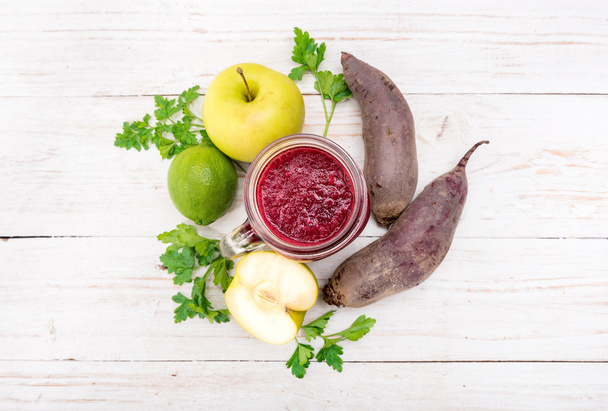 Smoothies with beet, apple, lemon, parsley in glass jars on a wooden background.  - Photo, image