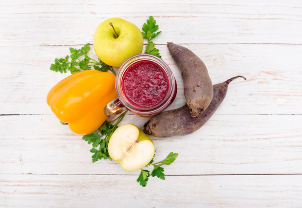 Smoothies with beet, pepper, apple, lemon, parsley in glass jars on a wooden background.  - Foto, Bild