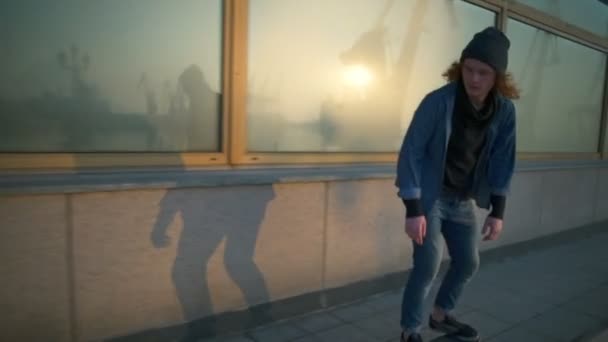 jongeman skateboarden in de zeehaven op dageraad slow motion - Video