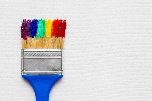 Paintbrush with paint on white artist canvas - Fotó, kép