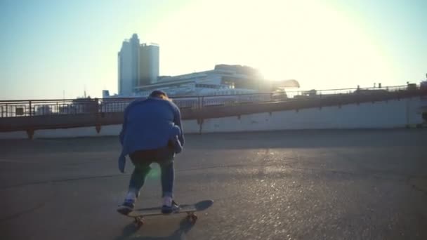 mladý muž skateboardingu v námořní přístav v svítání zpomalené - Záběry, video
