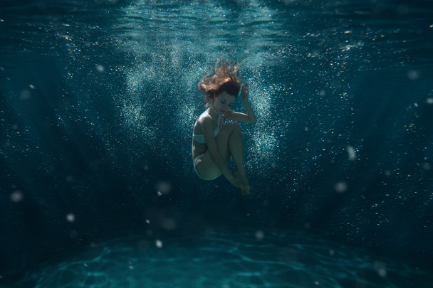 Woman dives underwater. - Фото, зображення