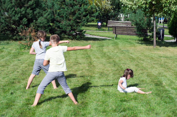 pienet lapset harrastavat urheilua puistossa ruohikolla
 - Valokuva, kuva