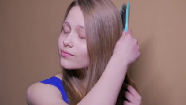 Attractive young teen girl combing hair. 4K UHD. - Video, Çekim