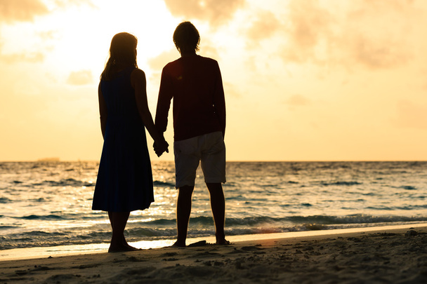 romantisches Paar hält Händchen bei Sonnenuntergang - Foto, Bild