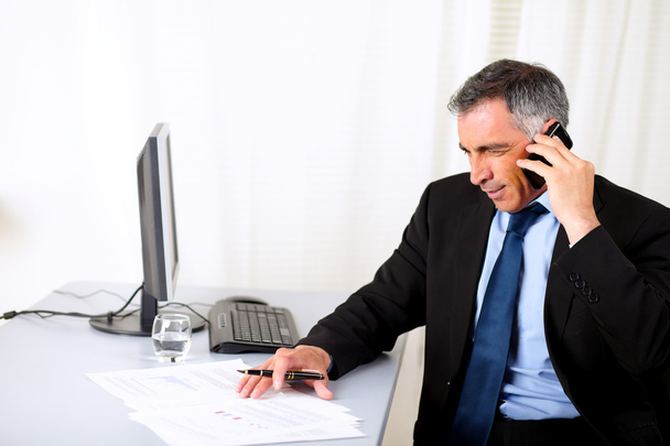 Бизнесмен выступает на мобильном телефоне в офисе
 - Фото, изображение