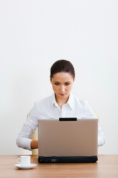 Joven mujer de negocios elegante mira a su computadora portátil y piensa en nuevos planes
 - Foto, imagen