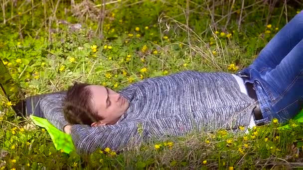 Man rust liggen op een bloeiende weide - Video