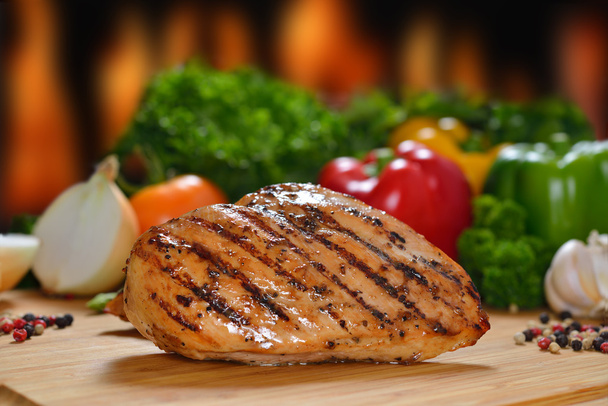 Roasted chicken breast and various vegetables on a chopping wood - Photo, Image