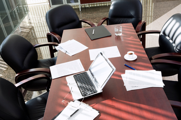 Empty boardroom: black chairs around table with business objects on it - Photo, Image