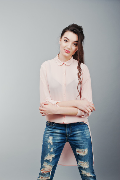 Portrait of young brunette girl wearing in pink blouse, ripped j - Foto, Imagem
