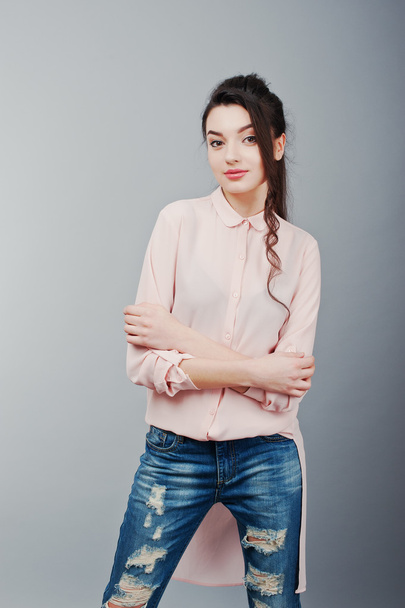 Portrait of young brunette girl wearing in pink blouse, ripped j - Foto, Bild