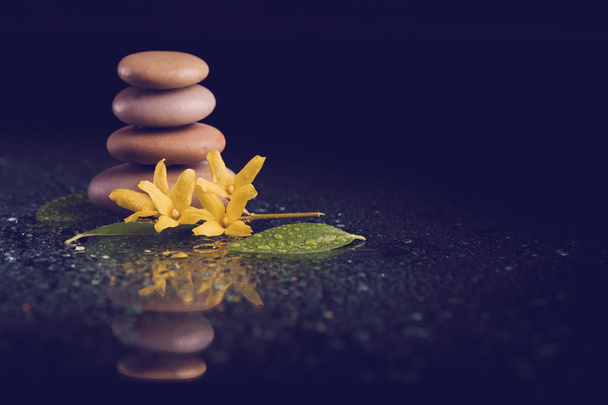 balancing zen stones on black with yellow flower - Photo, Image