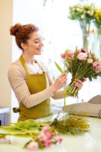 smiling florist woman making bunch at flower shop - Fotografie, Obrázek