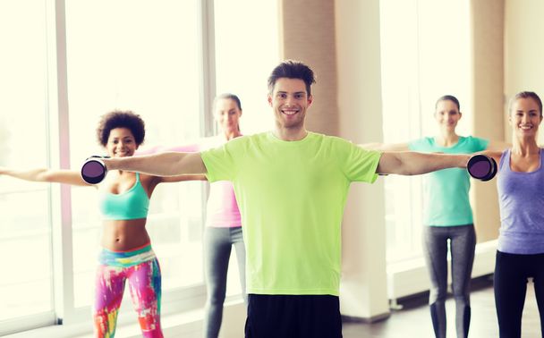 group of smiling people working out with dumbbells - Foto, Imagen