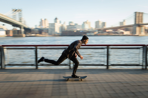 Jovem skatista cruzeiro para baixo na caminhada pedestre
 - Foto, Imagem