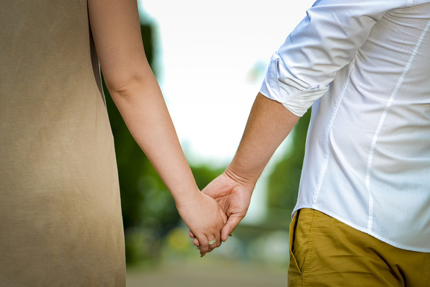 Man en vrouw houden handen in de natuur - Foto, afbeelding