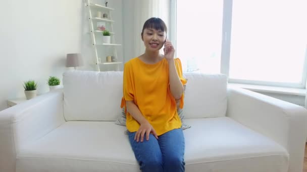 happy asian woman calling on smartphone at home - Felvétel, videó