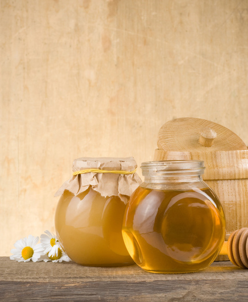 Glass jar full of honey and stick - Foto, imagen