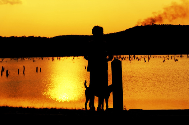 Kind und Hund Silhouette, Momente der Freude des Kindes. Fotografie auf dem Sonnenuntergang in der Natur - Foto, Bild