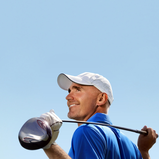 Улыбающийся гольфист держит клюшку для гольфа через плечо
 - Фото, изображение