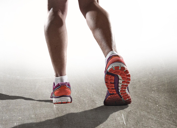 Füße aus nächster Nähe mit Laufschuhen und starken athletischen Beinen der Sportlerin beim Joggen - Foto, Bild