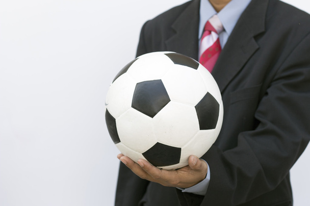 бизнесмен, держащий футбольный мяч - Фото, изображение