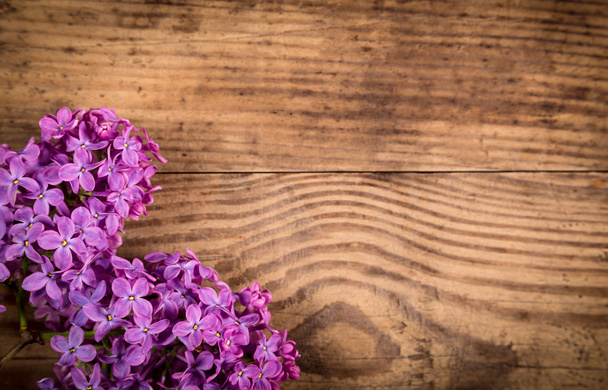 Lilac flowers on dark brown wood table - Фото, изображение