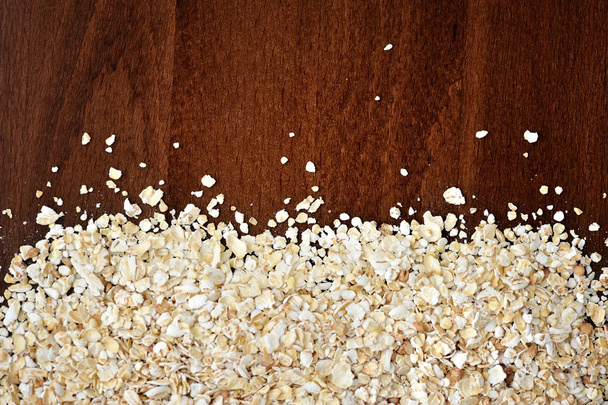 Close-up of oat flakeson dark wooden table as background or texture - Foto, immagini