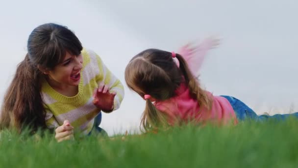 Anne ve kızı yeşil çimenlerin üzerinde oynama - Video, Çekim