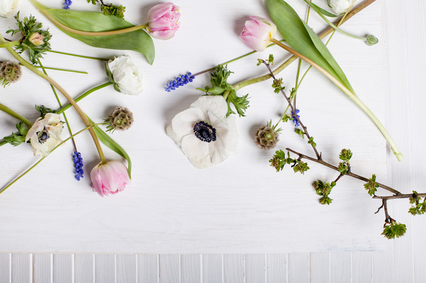 Diferentes flores de primavera en madera blanca y obturador
 - Foto, imagen