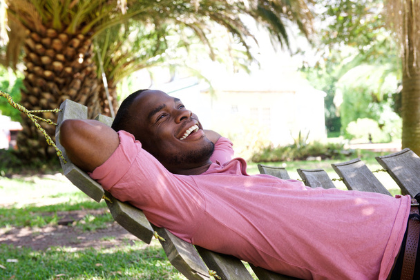 Entspannter junger Mann liegt im Freien - Foto, Bild