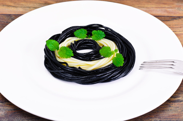 schwarze Spaghetti mit Tintenfischtinte, Tomate und Basilikum. mediterra - Foto, Bild