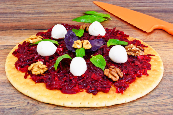 Pizza sokerijuurikkaan, pähkinän, juuston, mozzarellan ja basilikan kanssa
 - Valokuva, kuva