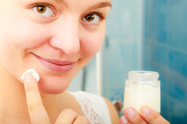 Woman applying  cream.  - Foto, afbeelding