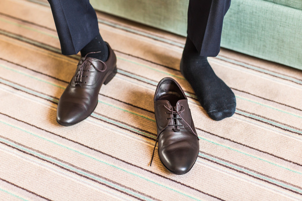Close-up jonge man gelijkmakende elegante schoenen binnenshuis - Foto, afbeelding