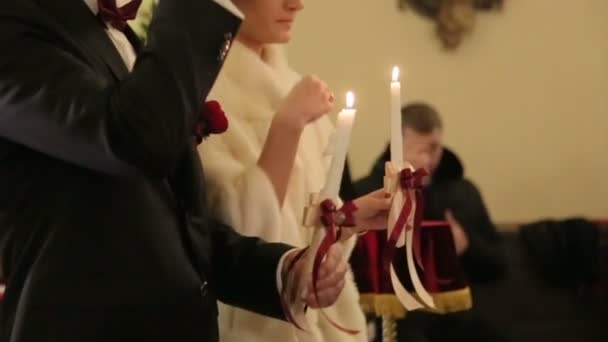 Γαμήλια τελετή του Happy κομψό μελαχρινή νύφη και κομψό γαμπρό κρατώντας κεριά στην παλιά εκκλησία - Πλάνα, βίντεο