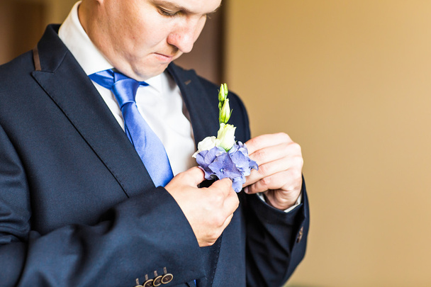 Чудова весільна бутоньєрка на костюмі нареченого крупним планом
 - Фото, зображення