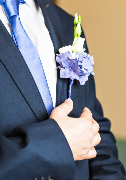 Prachtige bruiloft corsages op een kostuum van de bruidegom close-up - Foto, afbeelding