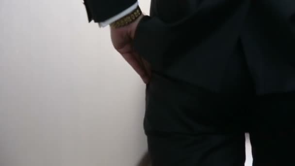 Groom in black wedding suit puts hand into the pocket and walks away. Wedding concept. Slow motion shot - Video