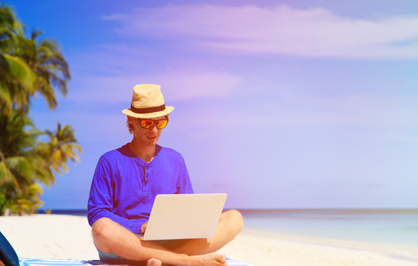 férfi trópusi tengerparton laptop - Fotó, kép