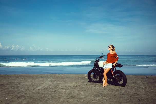 woman sitting on vintage custom motorcycle - Foto, Imagen