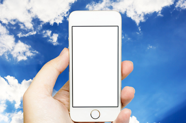 Мобильный телефон под рукой с небом
. - Фото, изображение