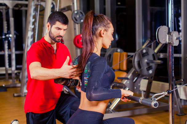 fitness, deporte, entrenamiento y concepto de personas - Entrenador personal que ayuda a las mujeres que trabajan en el gimnasio
 - Foto, Imagen