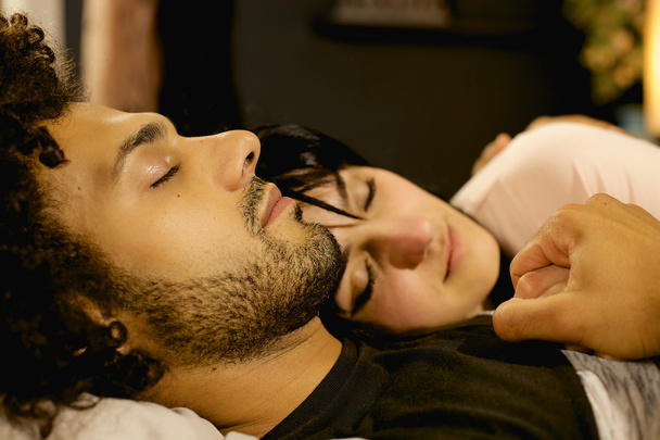 Casal apaixonado segurando uns aos outros enquanto dormem à noite na cama mulher fora de foco
 - Foto, Imagem