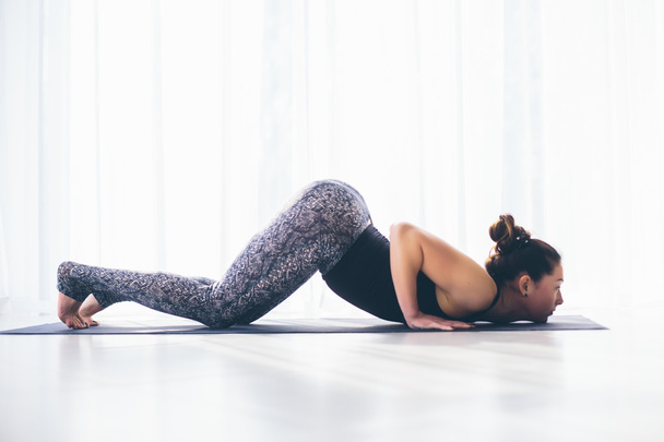 schöne Yoga-Frau Praxis in einer Trainingshalle Hintergrund. Yoga-Konzept. - Foto, Bild