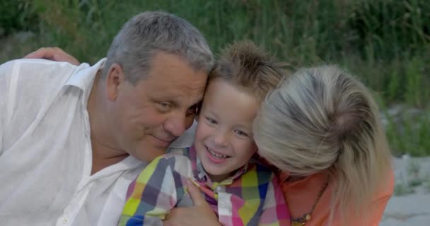 Dziadków, przytulanie i całując ich wnuk - Materiał filmowy, wideo