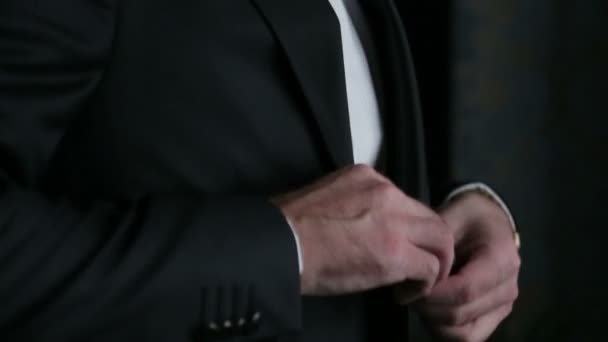 Handsome stylish groom adjusts his blak suit close up - Video, Çekim