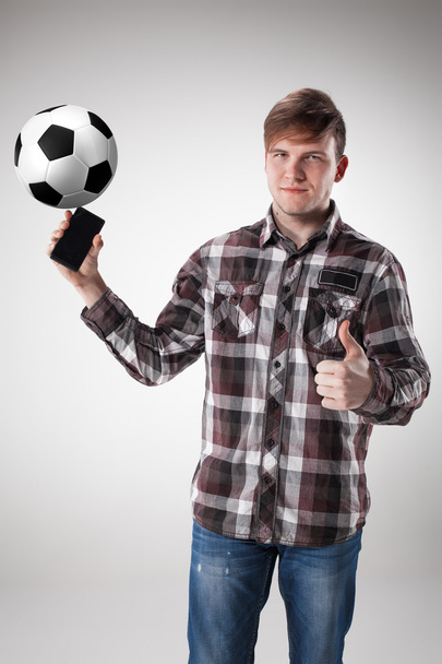 Portrait  of young man with smart phone and football ball - Foto, Imagen